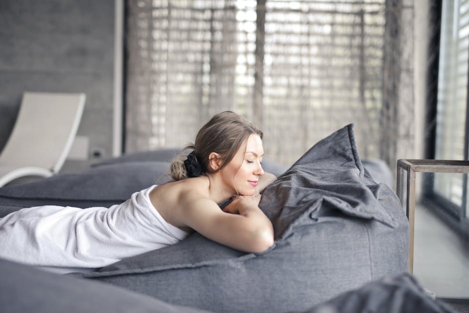 A serene moment indoors as a woman relaxes on a couch, enjoying a peaceful spa day